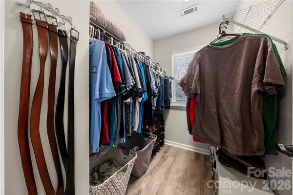 a view of walk in closet with clothes
