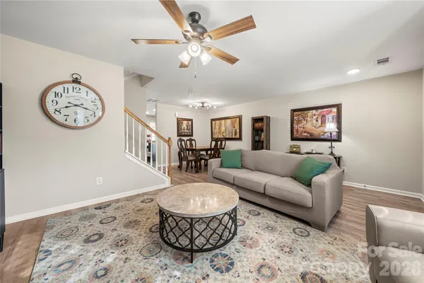 a living room with furniture a clock and a rug