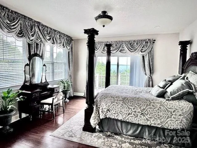 a bedroom with a bed dresser and a large window