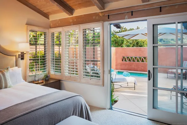 a bedroom with a bed and a large window with outer view