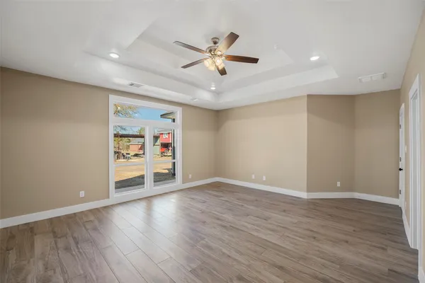 a view of an empty room with wooden floor