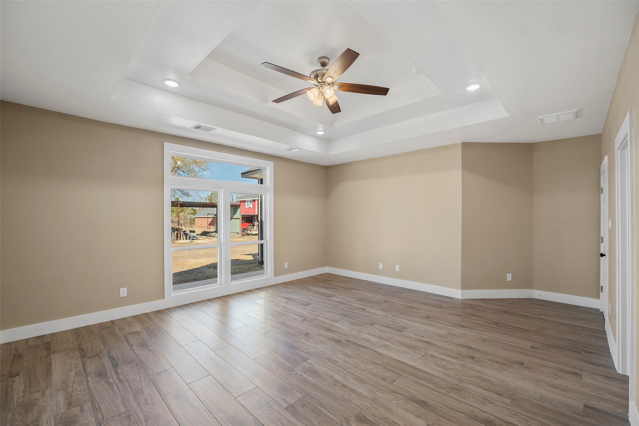24630 Cavan Street Hempstead, TX 77445 - Photo 22 of 31 a view of an empty room with wooden floor and a ceiling fan