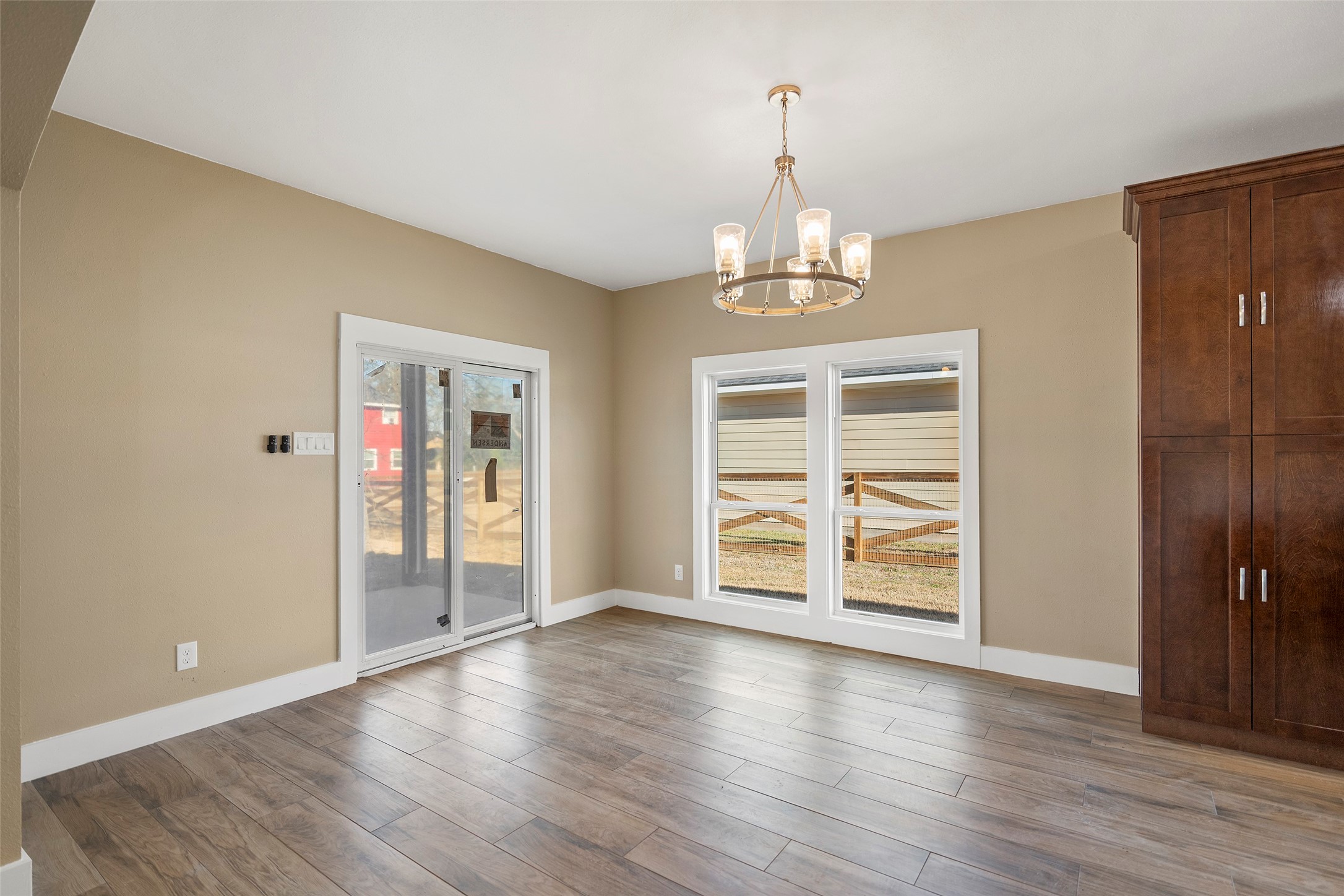 24630 Cavan Street Hempstead, TX 77445 - Photo 27 of 31 an empty room with wooden floor chandelier and windows