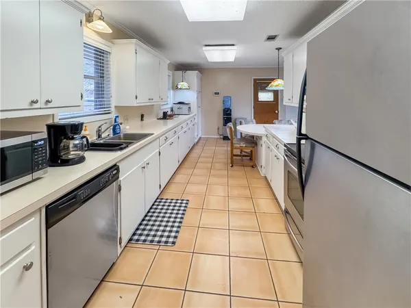 a kitchen with granite countertop white cabinets and white appliances