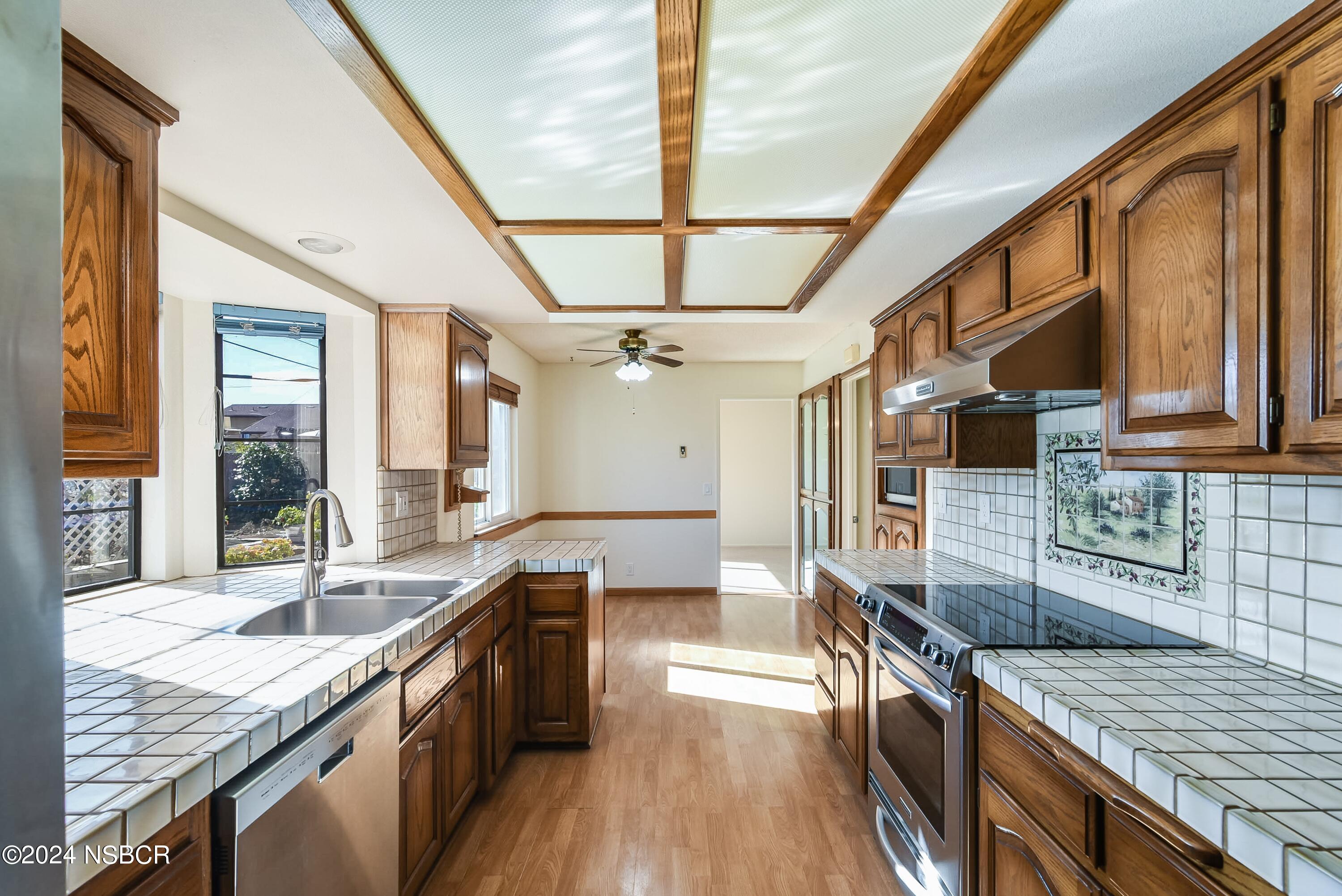 4487 Sirius Avenue Lompoc, CA 93436 - Photo 12 of 32 a large kitchen with stainless steel appliances granite countertop a lot of counter space and wooden floors