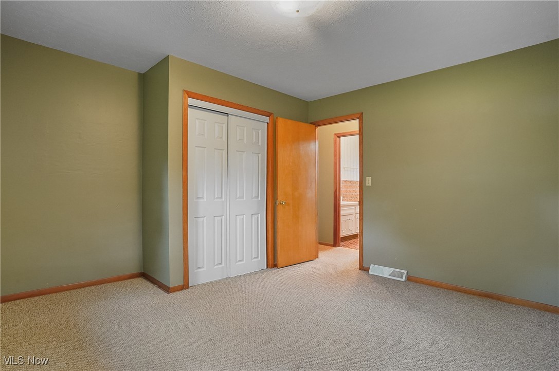 12395 Carter Road Painesville, OH 44077 - Photo 31 of 39 Unfurnished bedroom featuring carpet floors, a closet, and baseboards