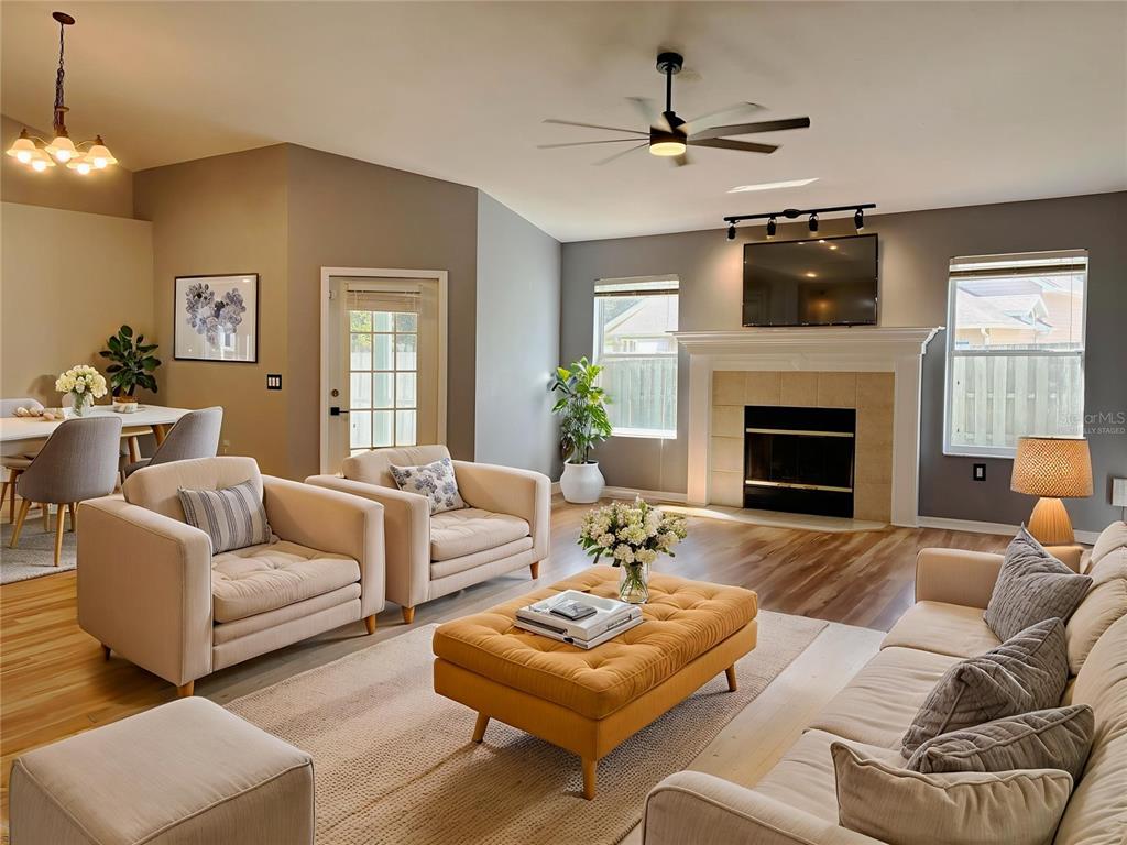 7637 Southwest 49th Place Gainesville, FL 32608 - Photo 11 of 47 a living room with furniture a fireplace and a chandelier