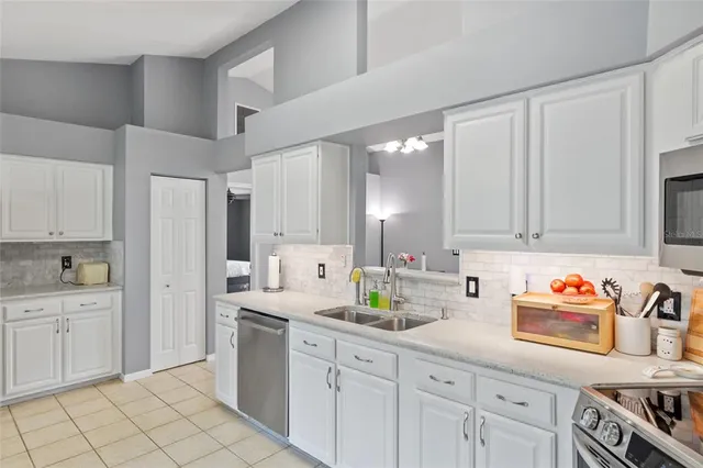 a kitchen with white cabinets and appliances