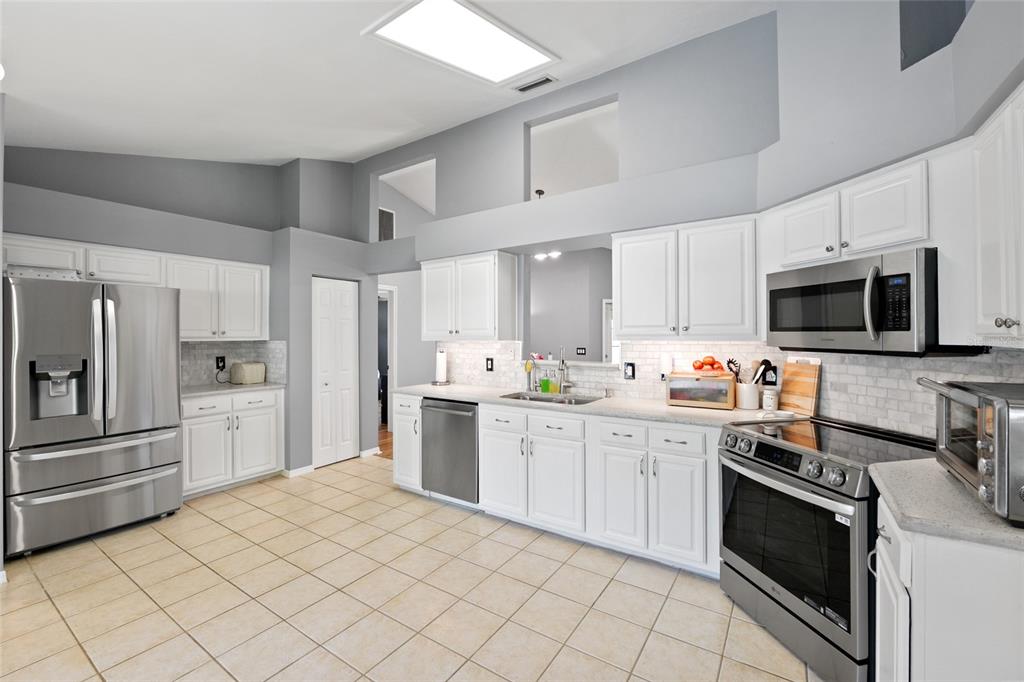 7637 Southwest 49th Place Gainesville, FL 32608 - Photo 13 of 47 a kitchen with white cabinets appliances and sink