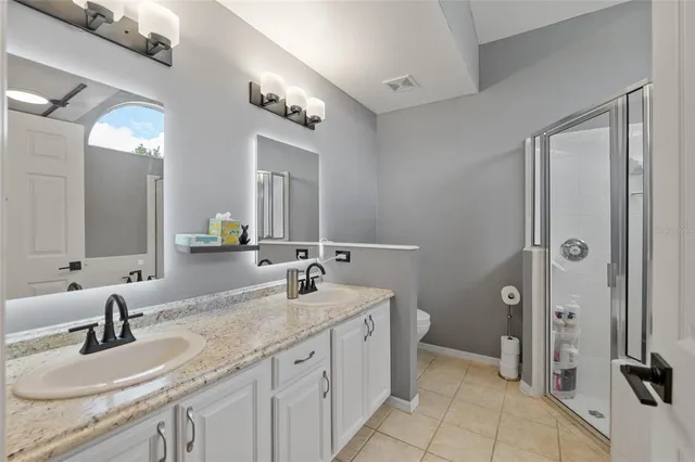 a bathroom with a granite countertop sink double and mirror