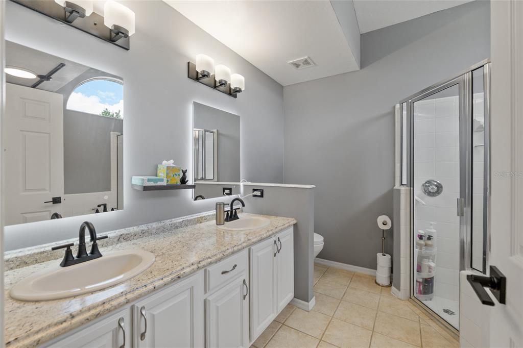 7637 Southwest 49th Place Gainesville, FL 32608 - Photo 18 of 47 a bathroom with a granite countertop sink double and mirror