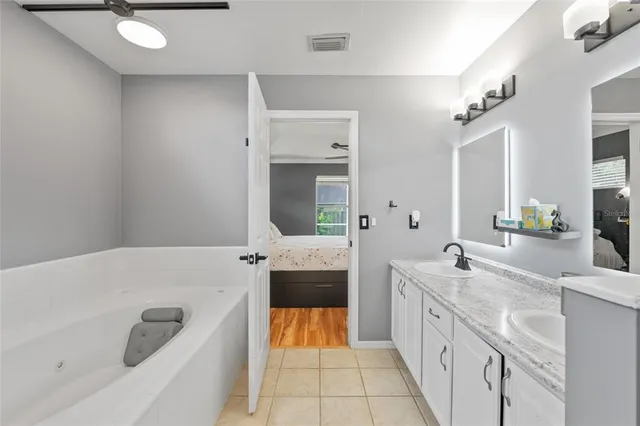 a bathroom with a tub sink and mirror