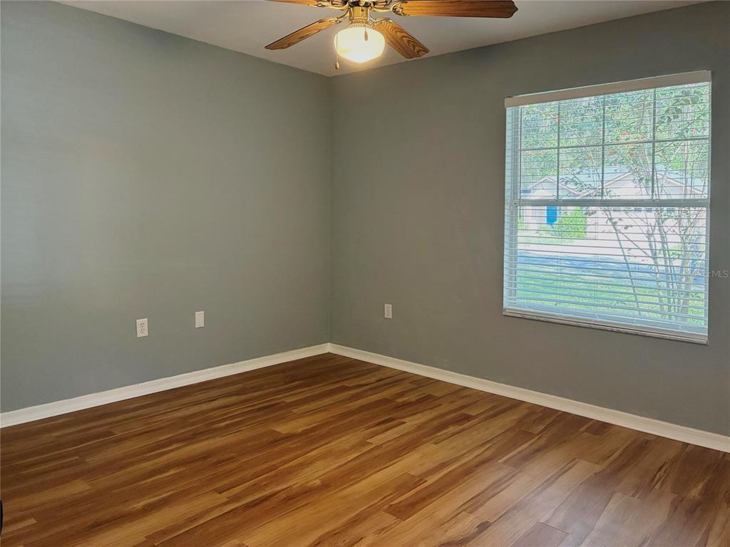 7637 Southwest 49th Place Gainesville, FL 32608 - Photo 23 of 47 a view of an empty room with window and wooden floor