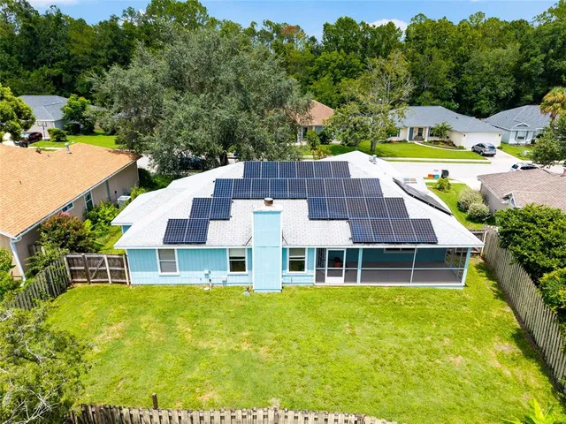 an aerial view of a house with swimming pool and large trees