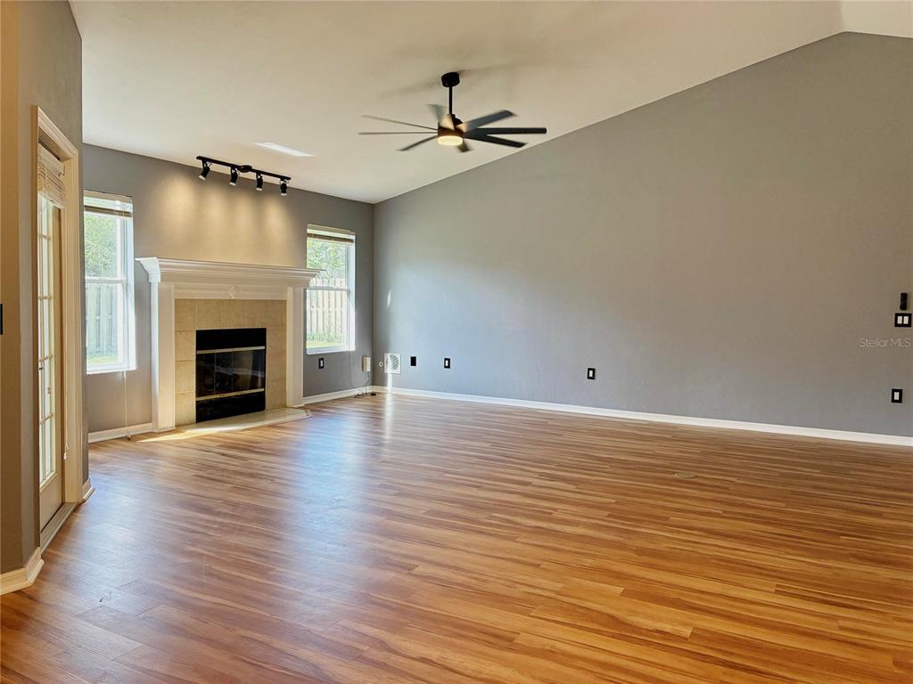 7637 Southwest 49th Place Gainesville, FL 32608 - Photo 8 of 47 an empty room with wooden floor fireplace and windows