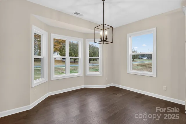 a view of a kitchen with wooden floor and stainless steel appliances