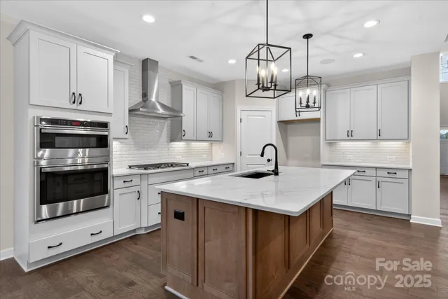 a kitchen that has a lot of cabinets and wooden floor