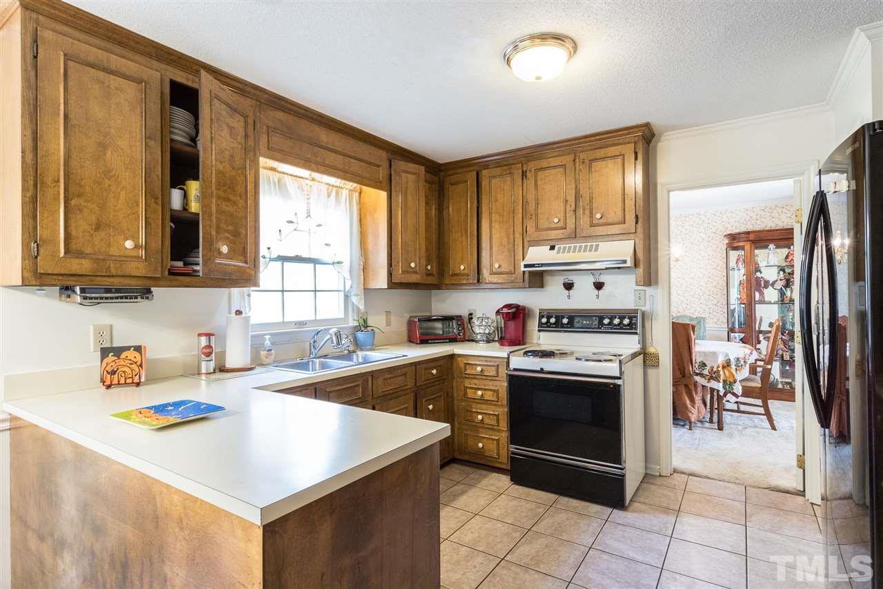 5363 Russell Road Durham, NC 27712 - Photo 13 of 28 a kitchen with a stove a sink and a refrigerator