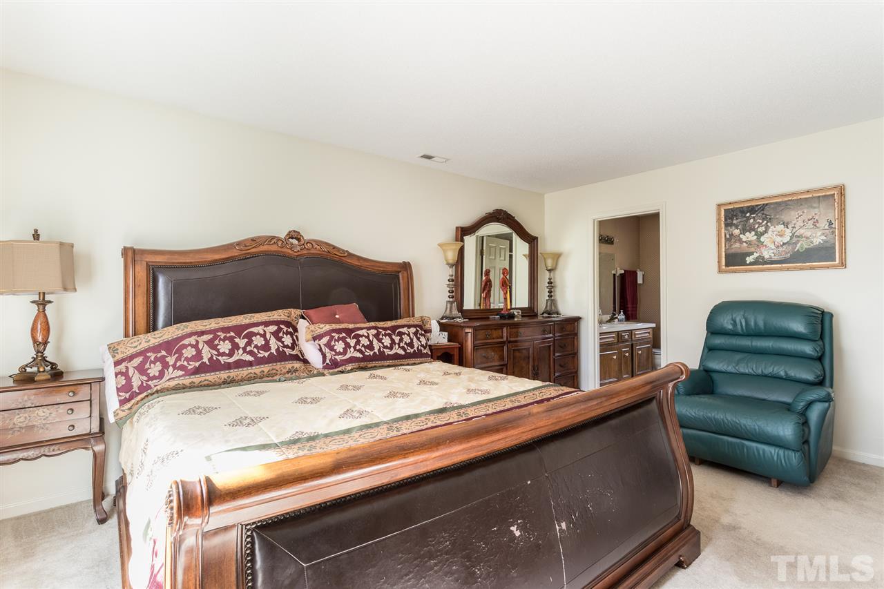 5363 Russell Road Durham, NC 27712 - Photo 19 of 28 a bedroom with a bed a mirror and lamp