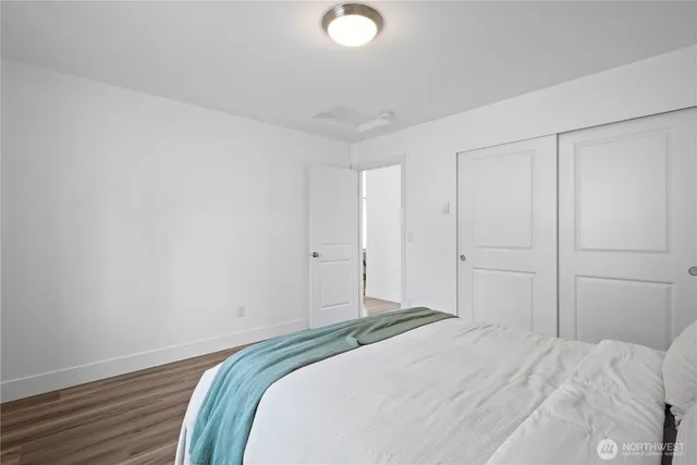 a bedroom with a bed and a lamp on the dresser