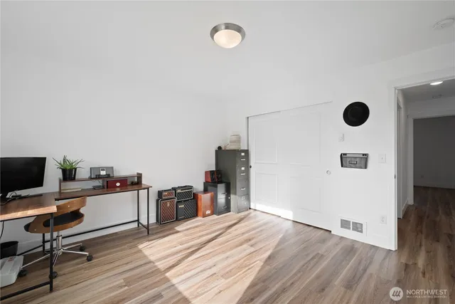 a view of a workspace with furniture and wooden floor