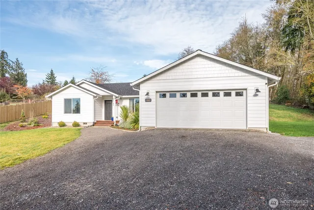 a view of a house with a yard and large trees