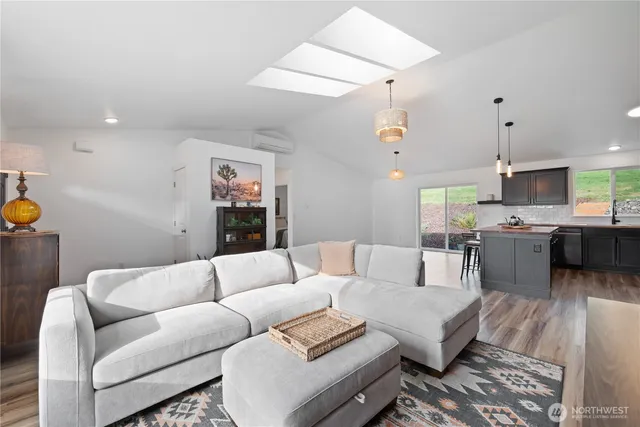 a living room with furniture kitchen view and a chandelier