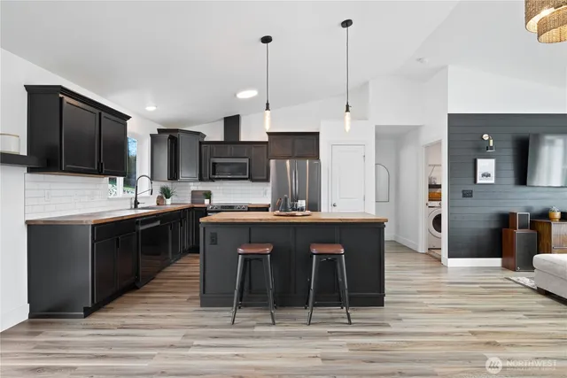 a kitchen with stainless steel appliances kitchen island granite countertop a sink counter space and cabinets