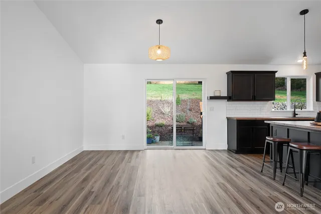 an empty room with wooden floor a fireplace and windows