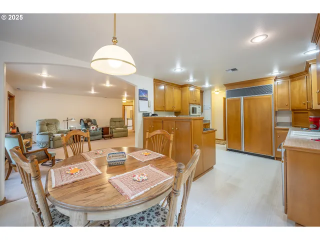 a living room with lots of chairs and kitchen view