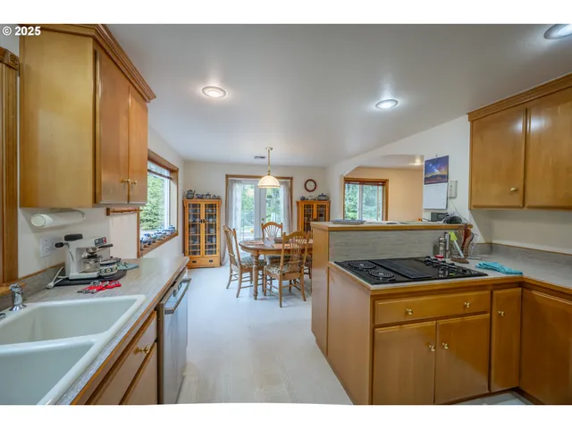 a kitchen that has a sink a table and chairs in it