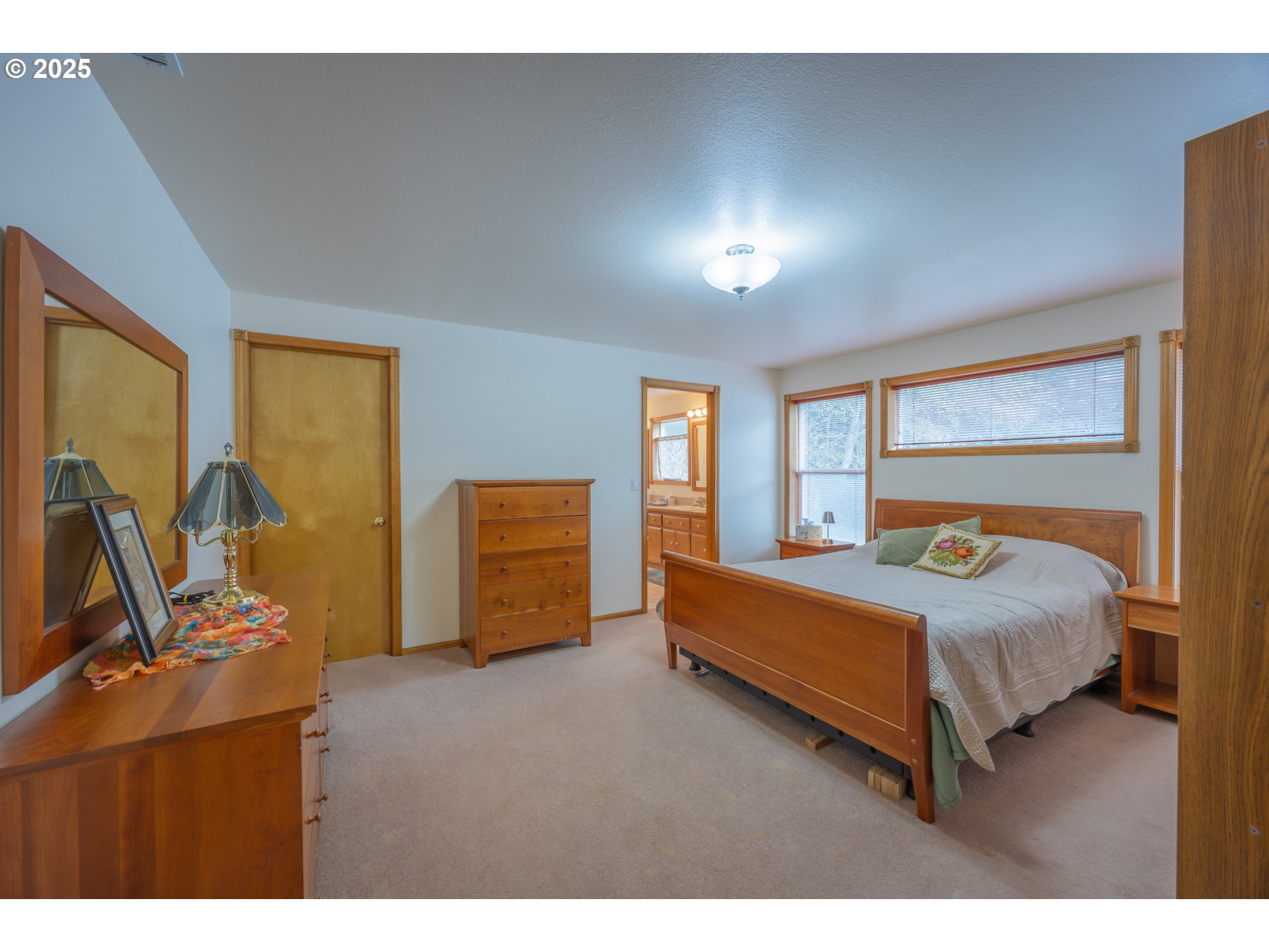 2184 13th Street Florence, OR 97439 - Photo 22 of 44 a bedroom with a bed and large windows