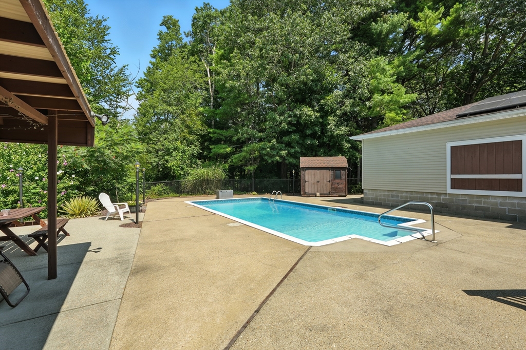 158 Chudy Street Three Rivers, MA 01080 - Photo 21 of 42 a backyard of a house with table and chairs under an umbrella