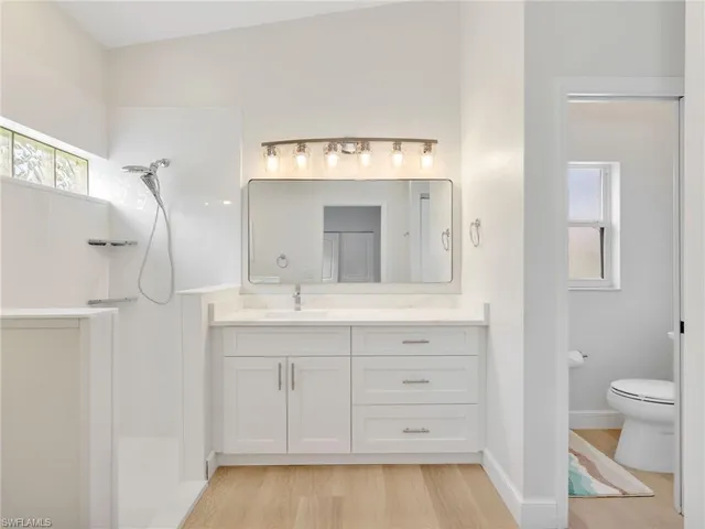 a bathroom with a sink a toilet and a mirror