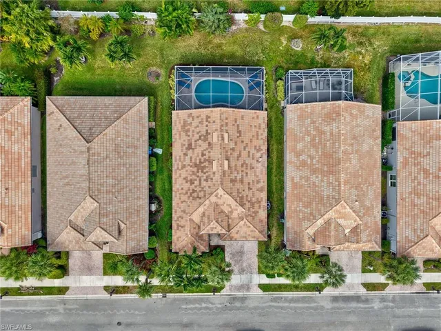 an aerial view of a brick house with a yard and plants