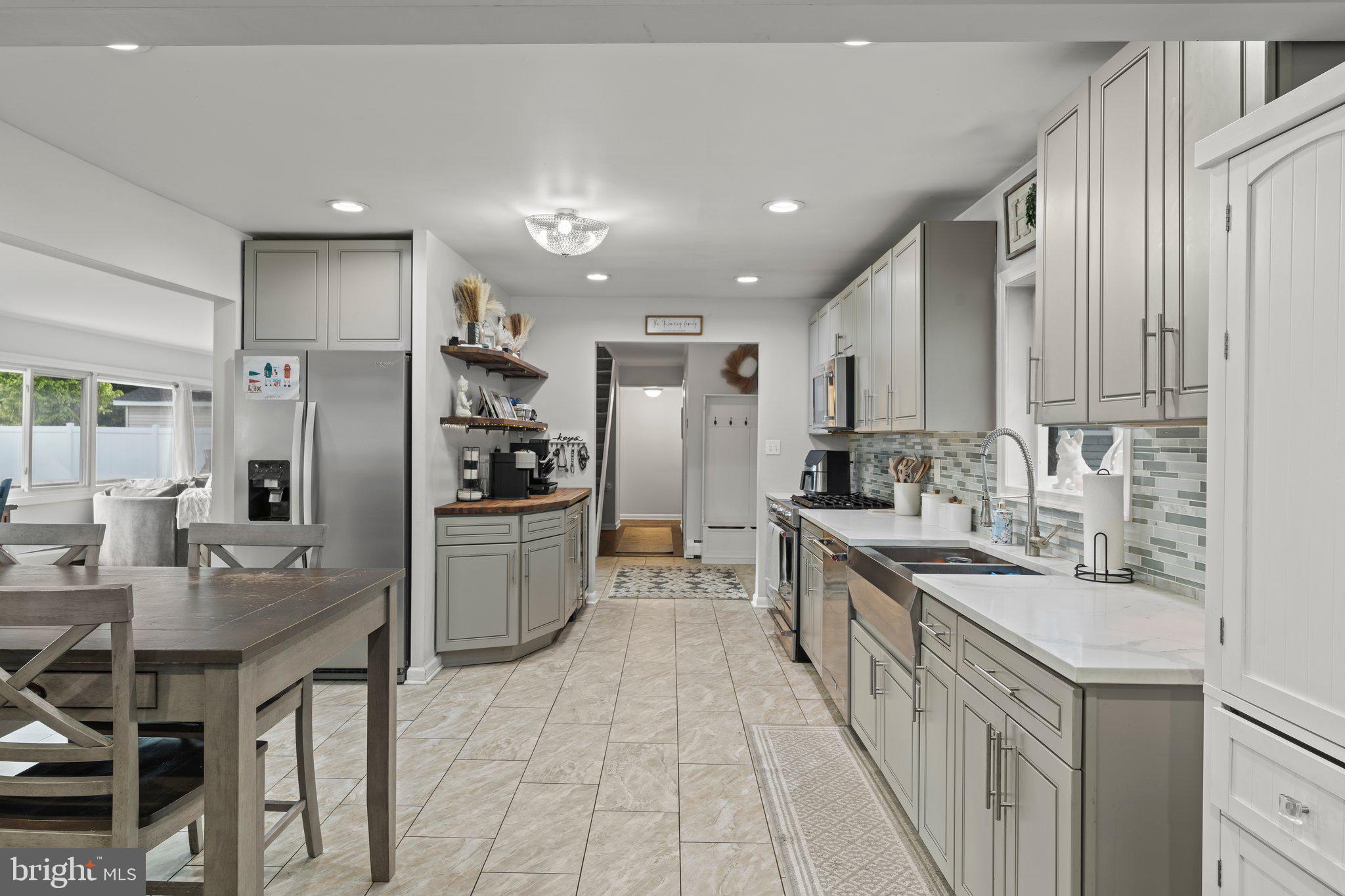 30 Roving Road Levittown, PA 19056 - Photo 4 of 40 a kitchen with stainless steel appliances granite countertop a refrigerator a sink dishwasher a stove and white cabinets with wooden floor