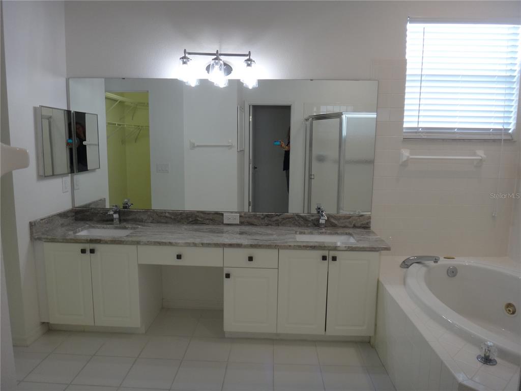 Undisclosed Address Sarasota, FL 34238 - Photo 13 of 26 a bathroom with a granite countertop bathtub a sink and a large mirror