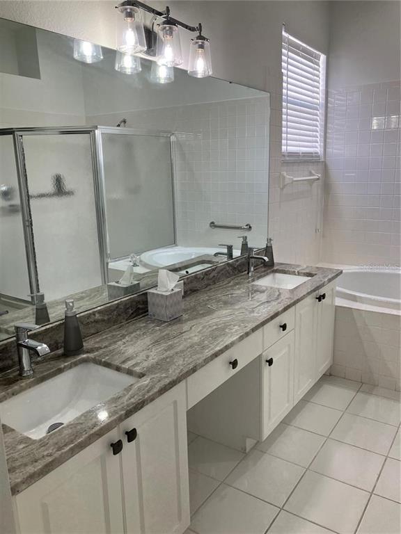 Undisclosed Address Sarasota, FL 34238 - Photo 14 of 26 a bathroom with a granite countertop sink a large mirror and a bathtub