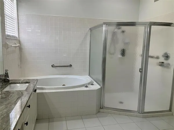 a bathroom with a bathtub a shower and a sink