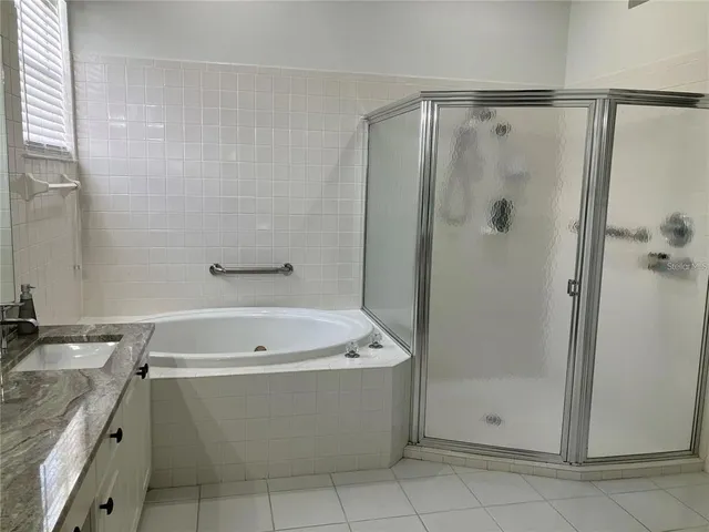 a bathroom with a bathtub a shower and a sink