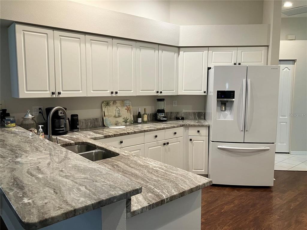 Undisclosed Address Sarasota, FL 34238 - Photo 6 of 26 a kitchen with white cabinets and stainless steel appliances
