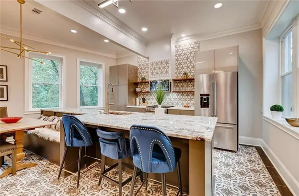 a kitchen with stainless steel appliances granite countertop a table chairs sink refrigerator and microwave