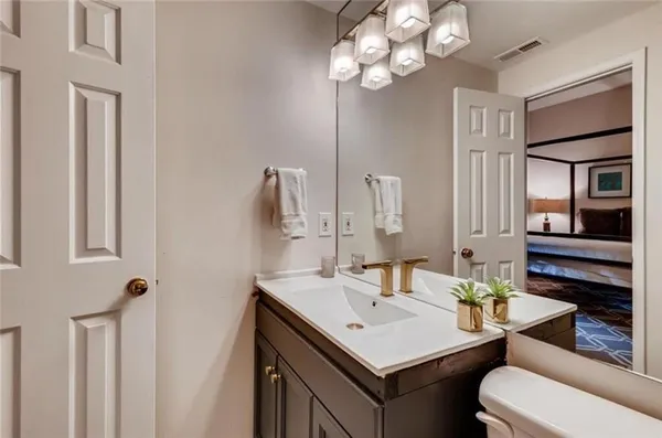 a bathroom with a sink a toilet and a mirror