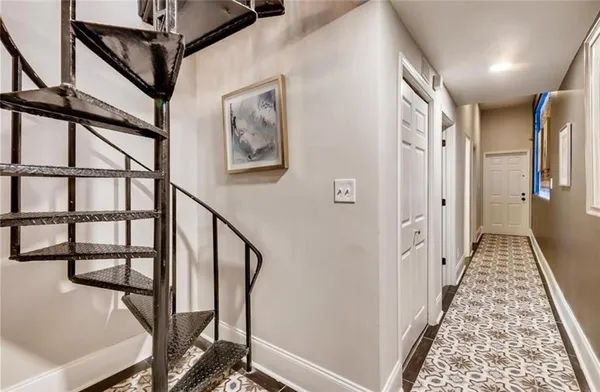 a view of a hallway with wooden floor and staircase
