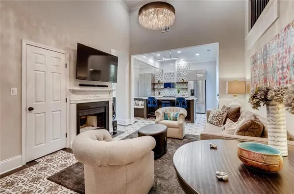 a living room with furniture a flat screen tv and kitchen view