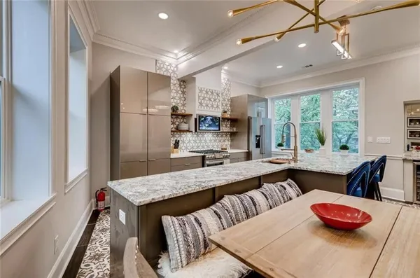 a kitchen with stainless steel appliances granite countertop a stove a refrigerator and a dining table