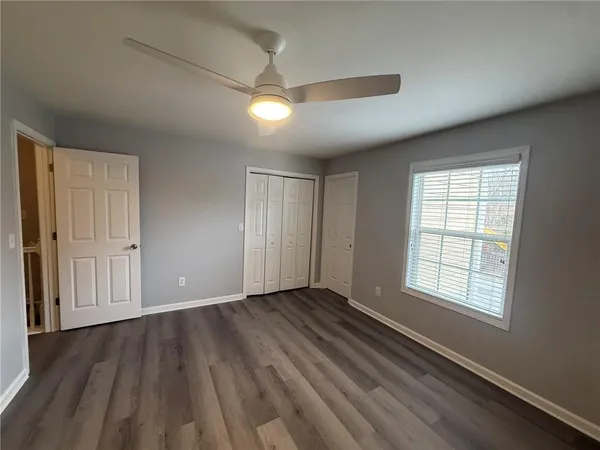 an empty room with wooden floor and windows