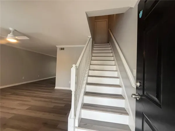 a view of staircase with wooden floor and white walls