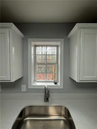 a kitchen with a sink a window and cabinets