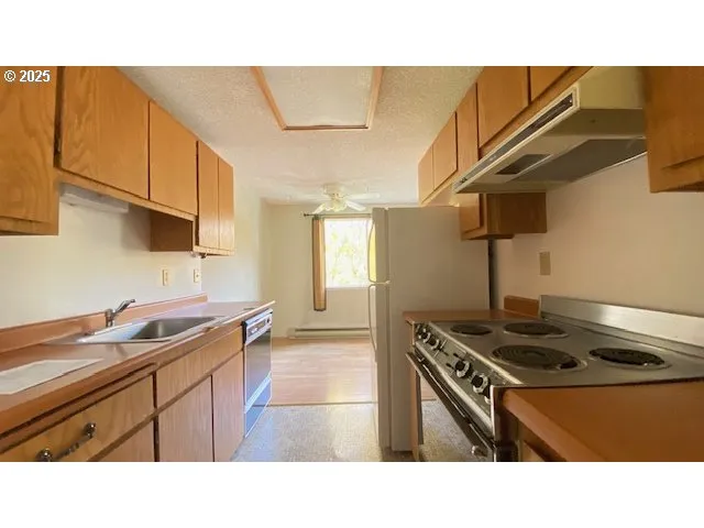 a kitchen with stainless steel appliances granite countertop a sink stove and cabinets